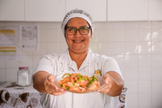 MERENDEIRA MOSTRANDO PRATO E RINDO