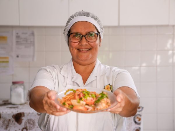 MERENDEIRA MOSTRANDO PRATO E RINDO