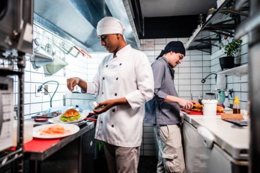 Chef young men making sandwiches on a commercial kitchen