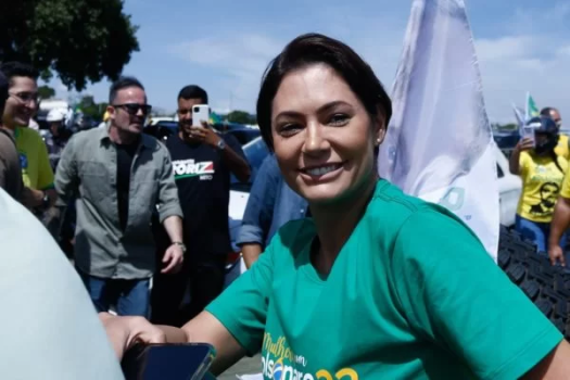 mICHELLE DE CAMISA VERDE NA FRENTE DE UMA MANIFESTAÇÃO