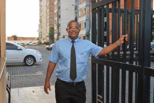 porteiro COM A MÃO NO PORTÃO